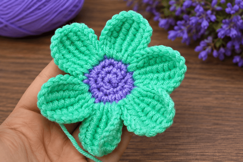 Zweifarbige Häkelblume in Grün und Lila mit sechs Blütenblättern